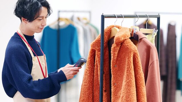 アパレルの在庫管理をする男性　商品管理　ハンディスキャナー　RFID