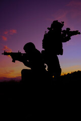 Two soldiers in a field at sunset