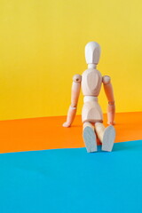 Concept of a tourist resting on the shore of the beach enjoying his vacation with an articulated wooden doll