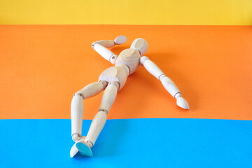 Concept of a tourist resting on the shore of the beach enjoying his vacation with an articulated wooden doll
