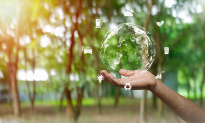 Hand holding with environment Icons over the Network connection on green background,environment concept.
