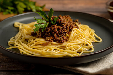 Spaghetti Bolognese in the grey plate on the grey backgroundSpaghetti Bolognese