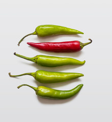 Hot chili peppers, green and red, on a light background