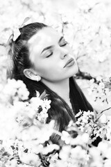 Beautiful woman portrait in sakura blossom background