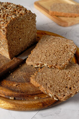 Close up view of a whole spelt bread on a wooden cutting board