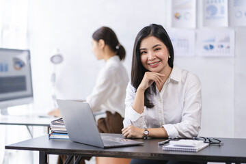 Smiling Asian businesswoman working on laptop in modern office Accountant Concept Finance Expert Analyze Business Report Graph financial chart financial chart corporate economy Banking Market Research