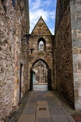 Vertical shot of an old European castle's gate with metal doors and arch. © Joshua P Jacks/Wirestock Creators