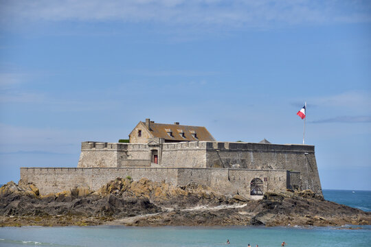 Ein Fort am Atlantik in Frankreich in der Totalen. Die franz&ouml;sische Flagge ist sichtbar. Der Himmel ist Blau und das Meer ist am Fu&szlig; des Schlosses sichtbar