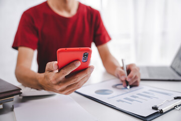 Fototapeta premium Portrait of a businessman's hand calculating sales in mobile via smartphone