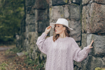 blonde in a white hat walks in the old park on an autumn day