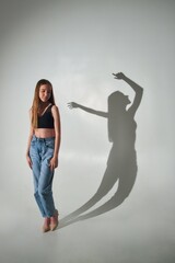A beautiful young girl and a shadow. Model studio shooting. Conceptual photography.