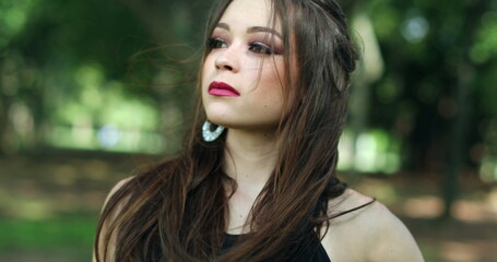 Naklejka premium Young confident woman in outdoor park nature posing