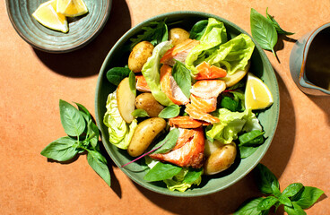 Roasted salmon and young potatoes salad with leafy greens and lettuce