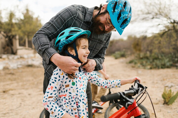 Father adjusting daughters (8-9) helmet