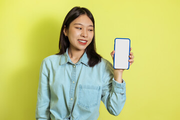 Naklejka premium Asian Woman Showing Mobile Phone With Empty Screen, Yellow Background