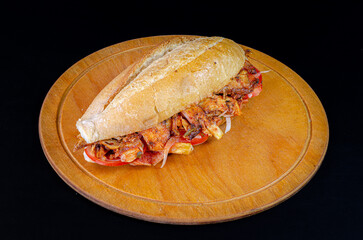 Chicken doner kebab in bread. Doner kebab in bread on wooden board on black background.
