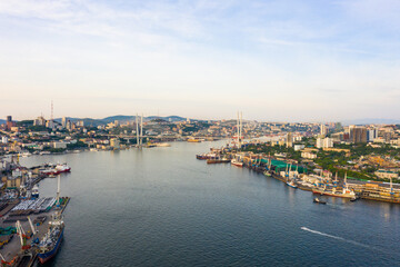 Fototapeta na wymiar View of the cityscape of Vladivostok. The famous Golden Bridge across the sea