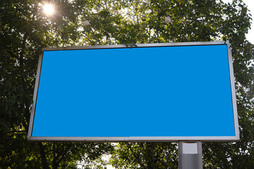 Street banner billboard empty on the background of trees and sun. Place for text. mockup