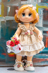 Smiling doll in a short-sleeved handmade rag dress on a colorful and diffuse background