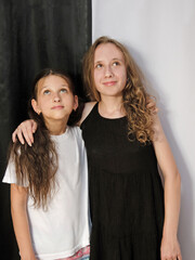 Portrait of two smiling young girls looking up on a black and white background