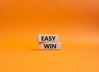 Easy win symbol. Wooden blocks with words 'Easy win'. Beautiful orange background. Business and 'Easy win' concept. Copy space.