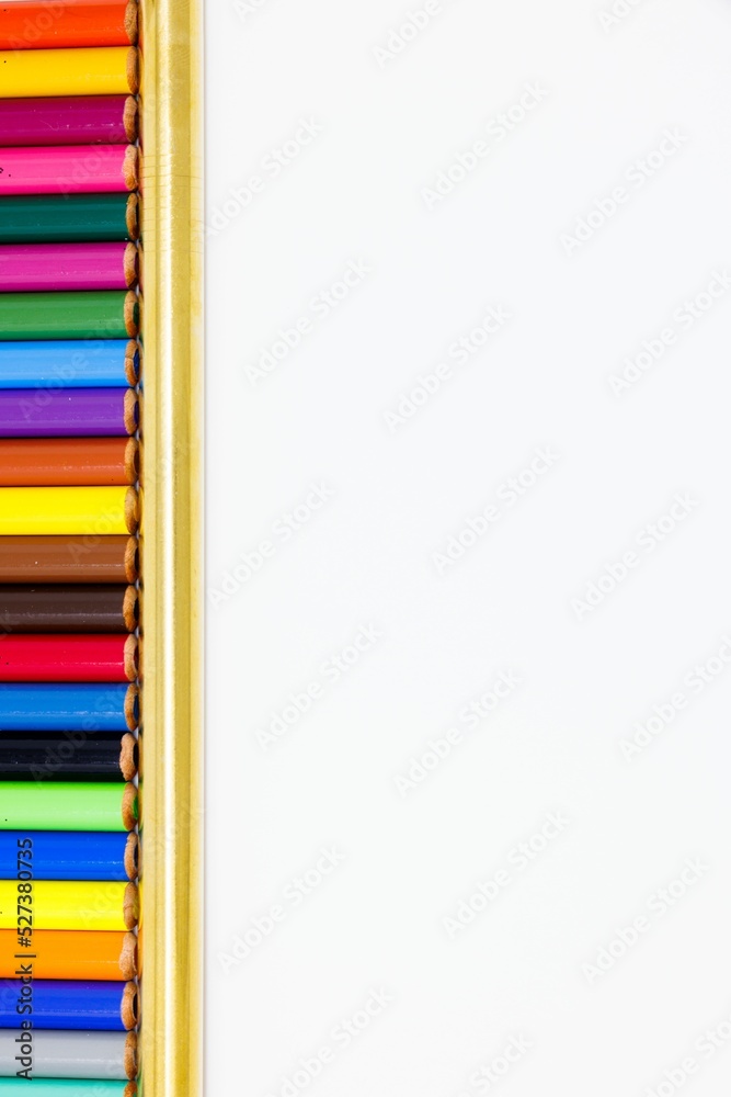 Wall mural Top view of aligned colorful pencils in the golden ruler isolated on the white background