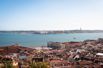 Fototapeta na wymiar View of the city and Orange Clay Rooftops overlooking the Tagus River in Lisbon, Portugal