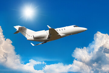 Fototapeta na wymiar White private jet flies in the air above the clouds