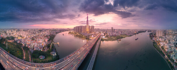 Aerial sunset view at Landmark 81 - it is a super tall skyscraper and Saigon bridge with...