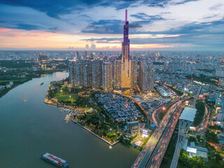Aerial sunset view at Landmark 81 - it is a super tall skyscraper and Saigon bridge with...