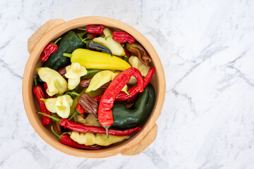 Home-grown pepper vegetables of different cultivar in a bowl. Top view of colorful peppers.