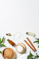 Fototapeta na wymiar Homemade Cosmetic laboratory. Cosmetic bottles, cream, serum, sea salt, lemon and essential oils at white table. Flat lay image with copy space.