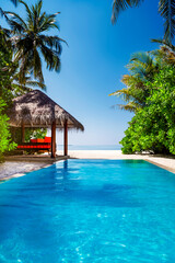 Landscape on Maldives island, luxury water villas resort with pool. Beautiful sky and ocean and beach with palms background for summer vacation holiday and travel concept. Luxury travel.