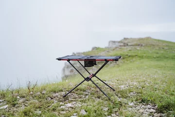 Selbstklebende Fototapeten Small size frame table for camping, furniture made of light materials, trekking in the mountains, table for eating, tourist equipment © Aleksey
