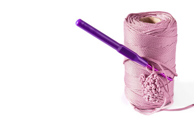 Hank of pink cord with purple hook and small crochet pattern