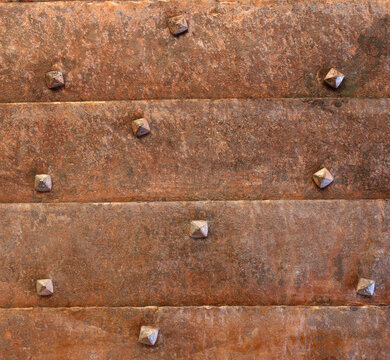 Medieval armored door rusty armor against siege. Ancient armory gate concept. Vintage background