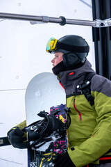 Naklejka premium man snowboarder portrait in ski lift cabin