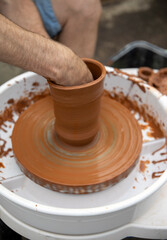 Fototapeta na wymiar Man making ceramic pot..Master making clay pottery..Potter's hands working clay on a potter's wheel.