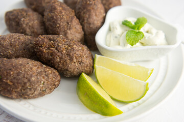 white plate with ready-to-eat kibbeh - Brazilian, Arabian, Lebanese, Syrian meat appetizer food