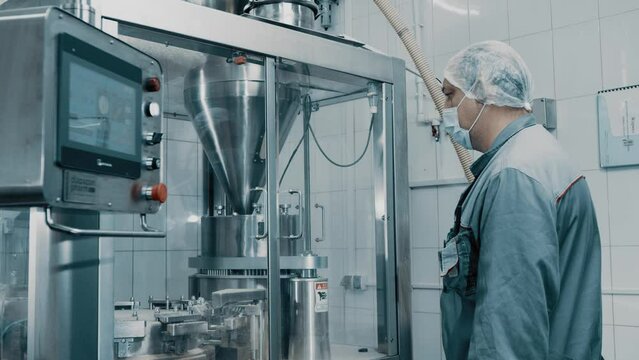 4K Machine operator working on pharmaceutical production line. Automatic Capsule Filling Machine. Automatic production line at a pharmaceutical company. Preparation and production of tablets close-up