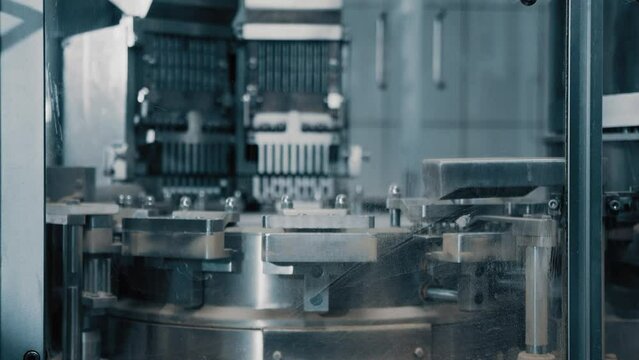 Automatic capsule filling machine, capsule filling device. Production line at a pharmaceutical company. The machine fills the capsule with contents. Production of drugs in tablets. Close up, DOF, 4K
