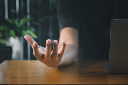 Male empty hand open palm up over computer laptop on desk. Business Technology Concept. - Powered by Adobe