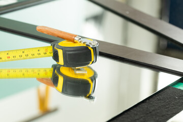 A ruler and a glass cutter, They lie on the mirror, The glass industry and the glazier's tools