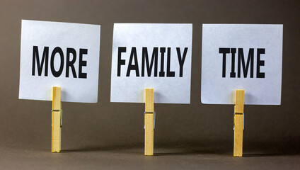 More family time and support symbol. Concept words More family time on white papers on wooden clothespins. Beautiful grey background. Business and More family time qoute concept. Copy space.