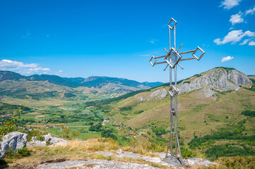 Cross on the top of a mountain with stunning view over the landscape in Apuseni Mountain Range in Transylvania, Romania