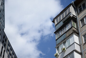 old soviet nine-story house with balconies  windows of different textures against the background of a blue sky white clouds in Kyiv, buildings of 70s lukyanovkapanel building, air conditioners