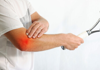 Closeup a man with tennis racket holding his elbow with pain isolated on white background. A tennis...