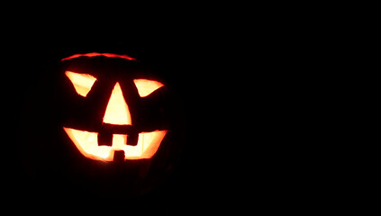 Halloween nightmare with glowing jack-o-lantern in the darkness. With space for your own text