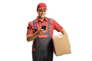 Male courier in a uniform holding a box and typing on a mobile phone - obrazy, fototapety, plakaty