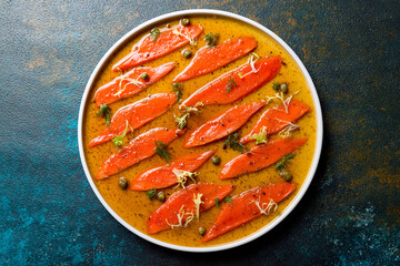 sockeye carpaccio with sauce on a white plate top view